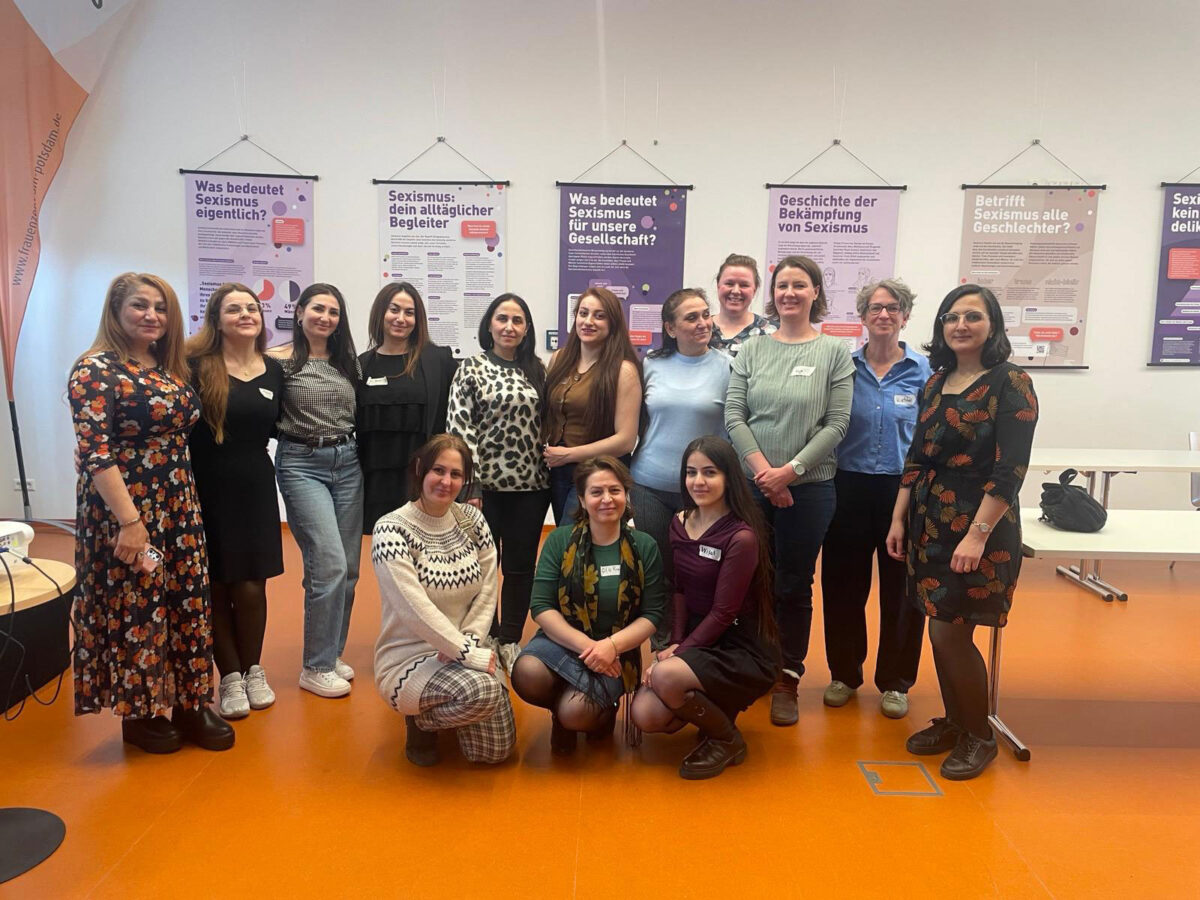 Eine große Gruppe von Frauen verschiedener Nationalitäten steht zusammen und lächelt in die Kamera